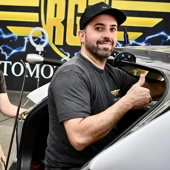 RG7 technician giving a thumbs-up from inside a car during repair